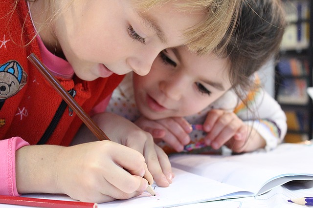 Des enfants à leur bureau qui écrivent